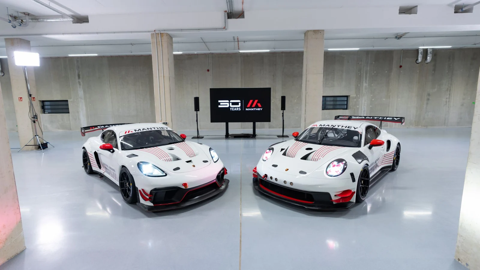 Jubilejna dirkalnika Porsche Cayman in 911 Manthey MR 30 v garaži