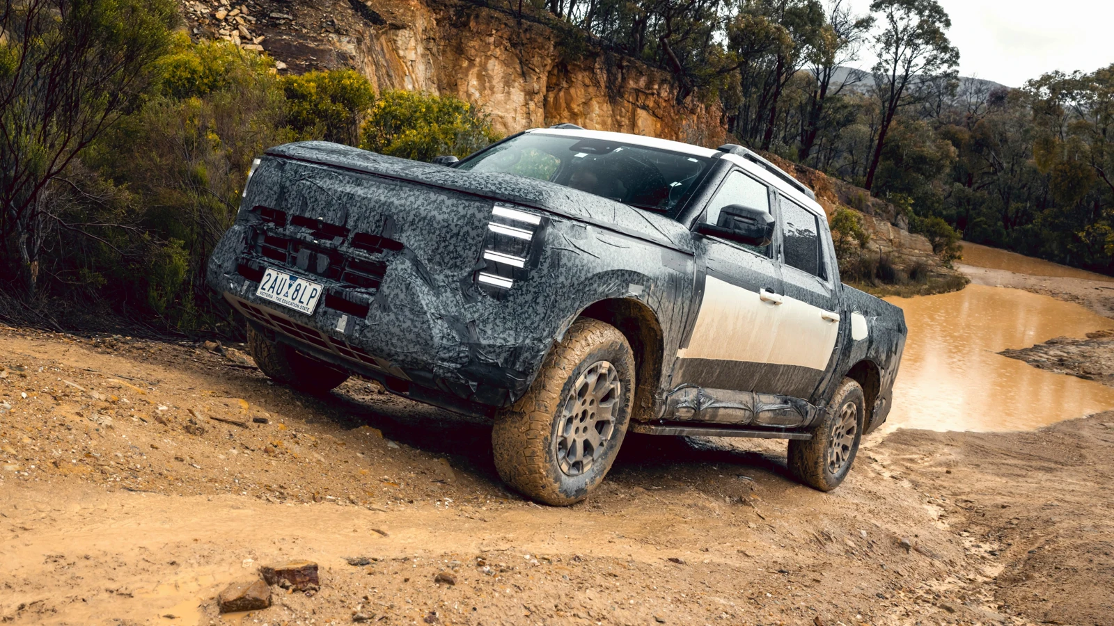 Kamufliran Nissan Navara Pro PHEV vozi čez blatno vodo na razvojnem preizkusu