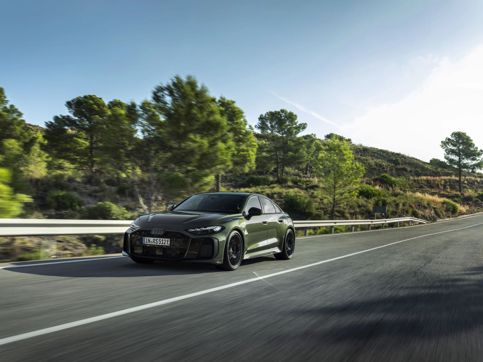 Zelen Audi RS 5 Sedan med vožnjo mimo cestne ograje