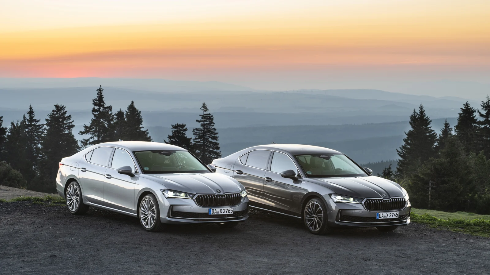 Dva Superba liftback na gorskem razgledišču ob sončnem vzhodu
